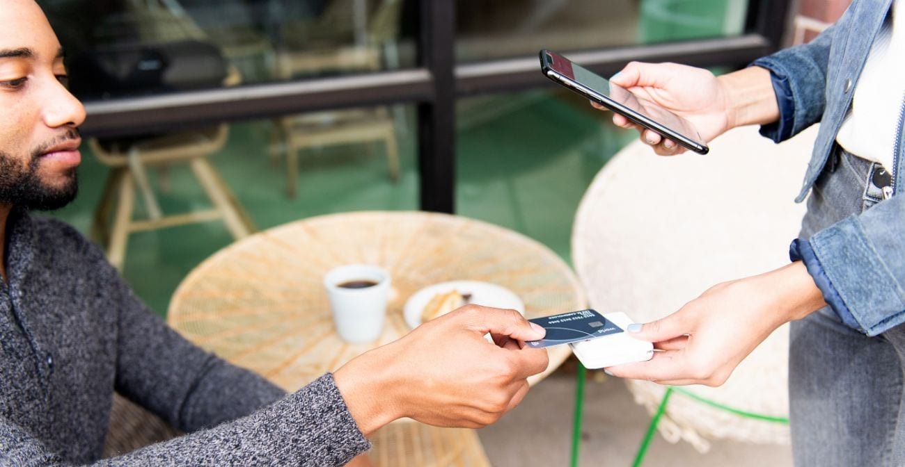 Customer in cafe uses credit card to pay on mobile POS system