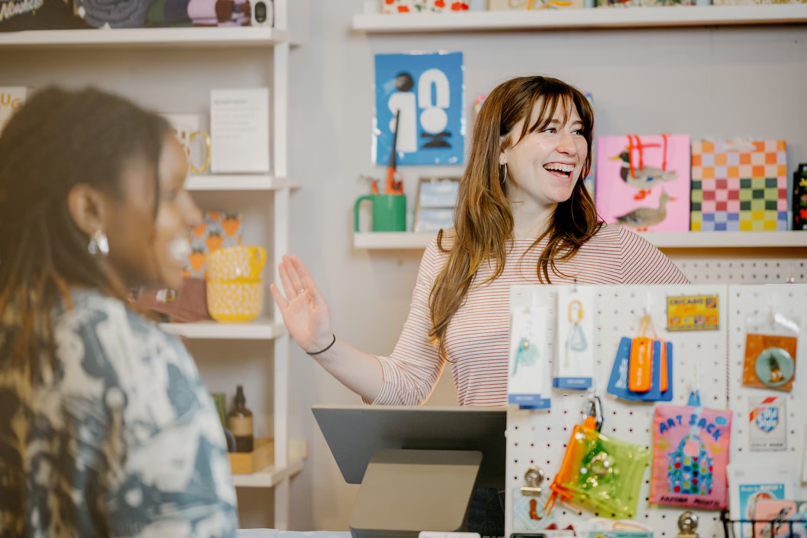 Retailer and customer share laughs during sale near stationary POS device